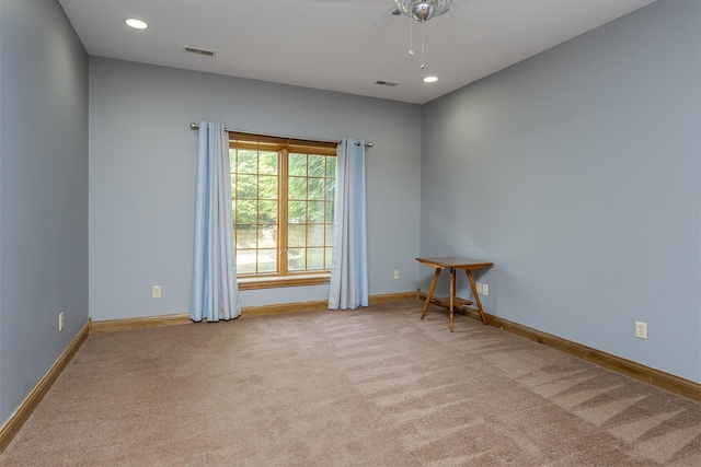 spare room with baseboards, ceiling fan, carpet flooring, and visible vents