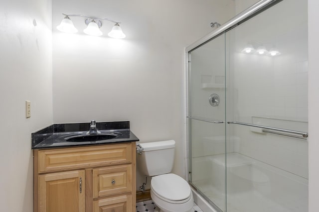 full bathroom featuring vanity, a shower with door, and toilet