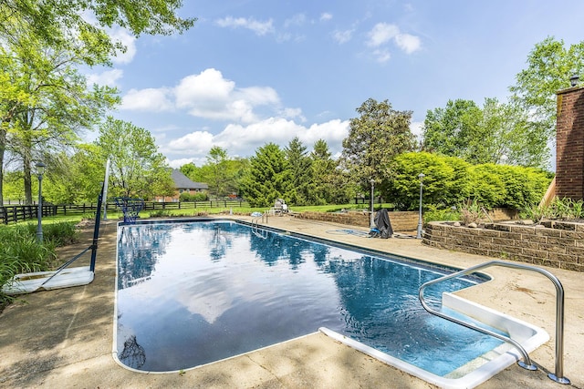 view of pool with a fenced in pool, fence, and a patio area
