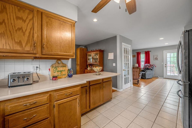 525 Hiawatha Trl, Frankfort, KY 40601 - kitchen with freestanding refrigerator, light tile patterned floors, a ceiling fan, tasteful backsplash, and brown cabinets