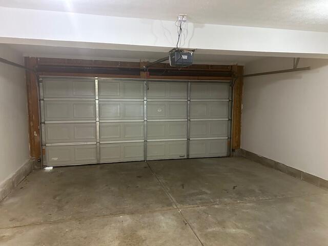 garage with baseboards and a garage door opener