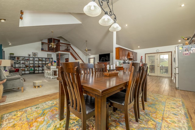 dining space featuring lofted ceiling, light wood-type flooring, a chandelier, a ceiling fan, and recessed lighting