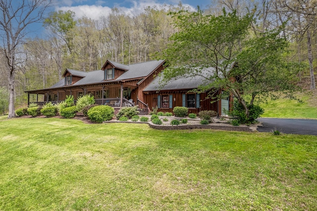 view of front of house with a front yard, covered porch, and driveway