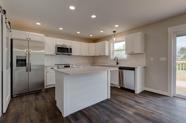 kitchen with a sink, light countertops, dark wood finished floors, stainless steel appliances, and tasteful backsplash