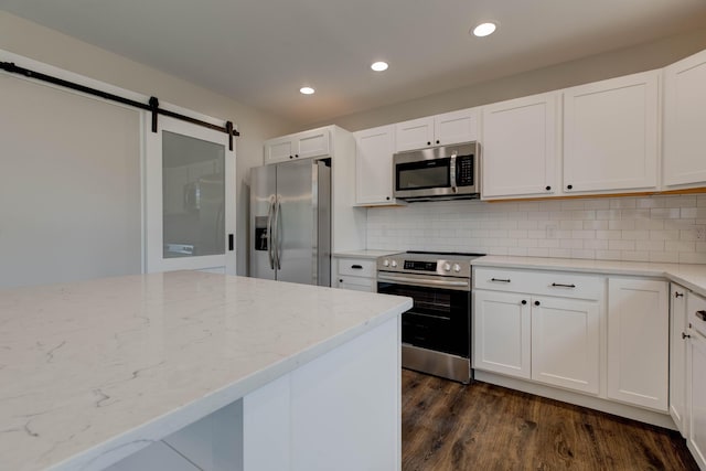 kitchen featuring recessed lighting, appliances with stainless steel finishes, dark wood-style floors, and light stone counters
