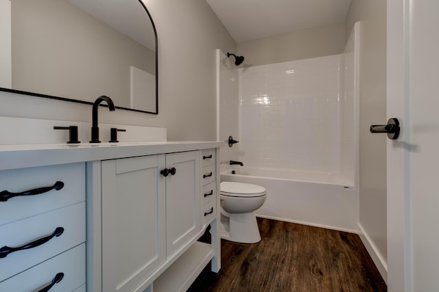 full bath featuring shower / bathtub combination, toilet, wood finished floors, and vanity