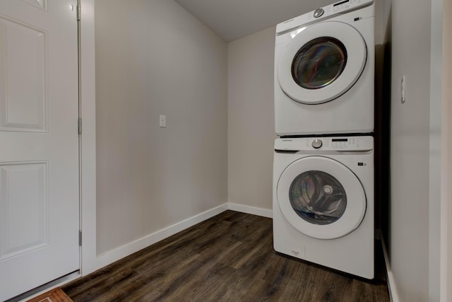 washroom featuring baseboards, stacked washer and clothes dryer, dark wood finished floors, and laundry area