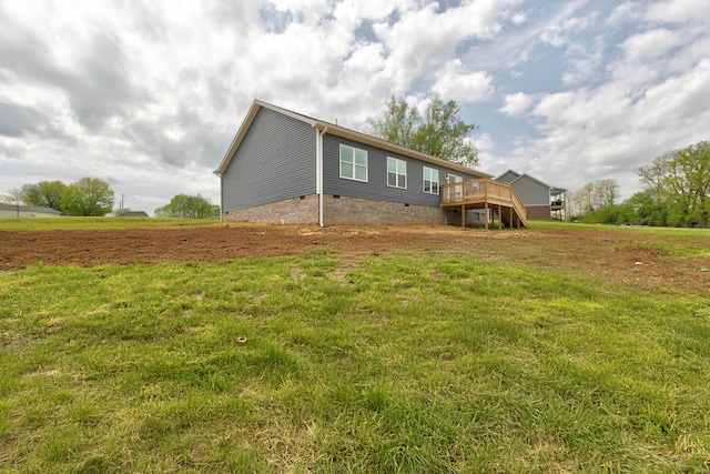 rear view of house with a wooden deck, a yard, and crawl space