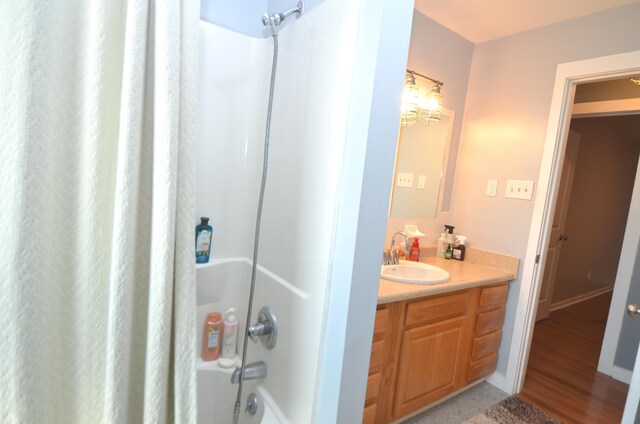 bathroom featuring shower / bath combo with shower curtain, baseboards, and vanity