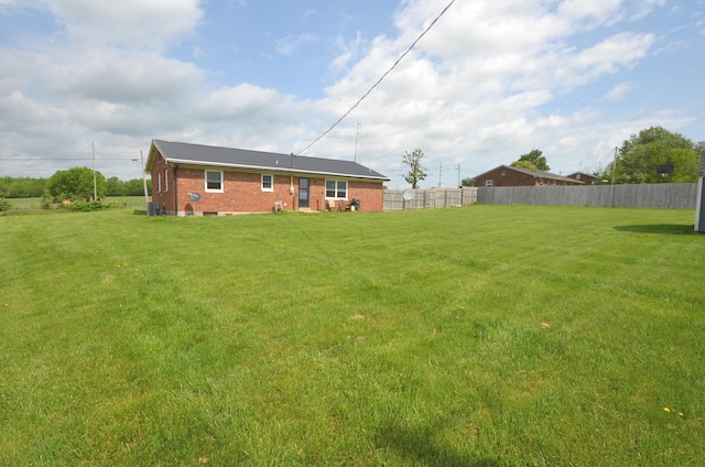 view of yard featuring central air condition unit and fence