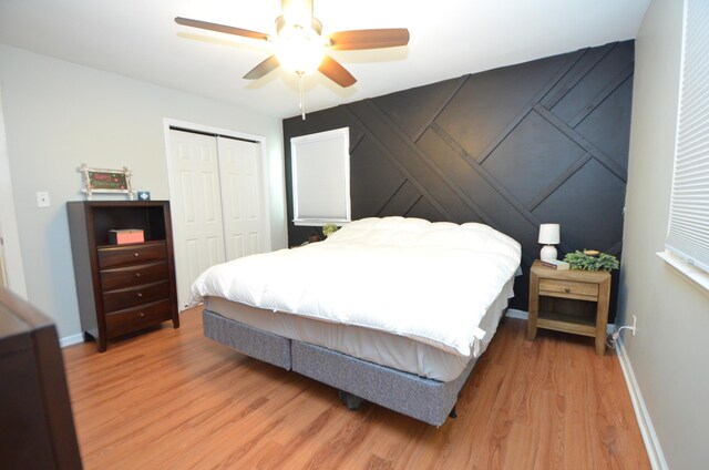 bedroom featuring baseboards, a ceiling fan, a closet, and light wood-type flooring