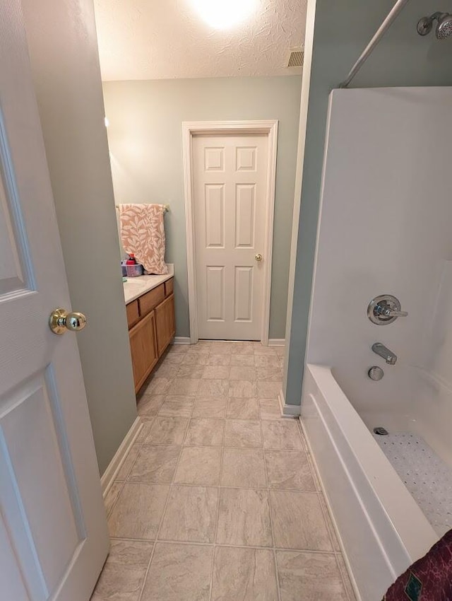 full bath featuring visible vents, baseboards, bathtub / shower combination, and vanity