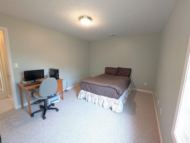 carpeted bedroom featuring a textured ceiling, visible vents, and baseboards