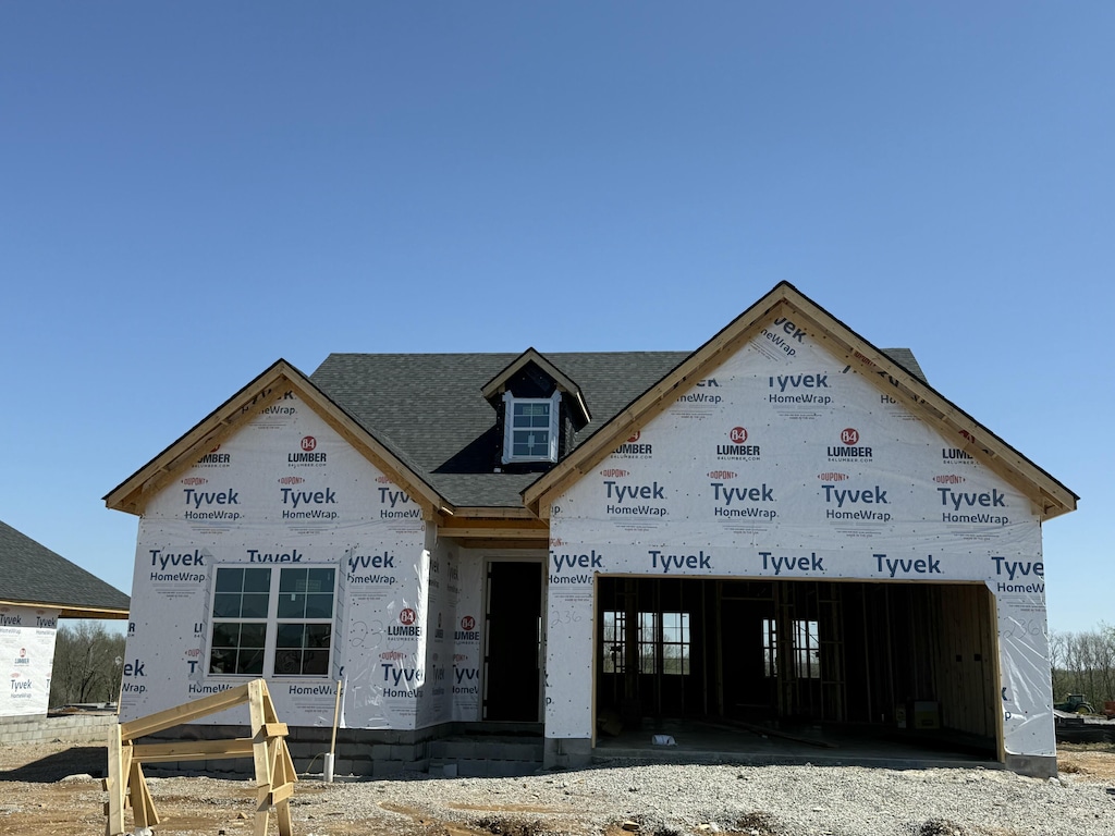property in mid-construction with a shingled roof