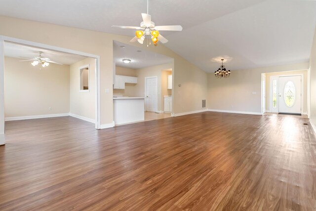unfurnished living room featuring visible vents, wood finished floors, baseboards, ceiling fan with notable chandelier, and lofted ceiling