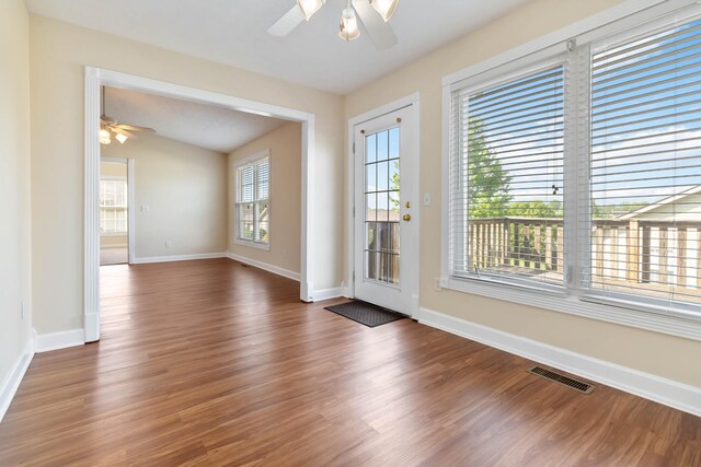 spare room with baseboards, ceiling fan, visible vents, and wood finished floors