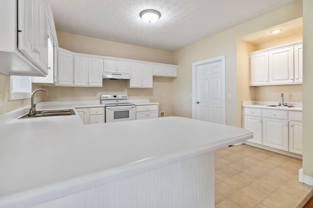 kitchen with white cabinets, a sink, electric stove, a peninsula, and under cabinet range hood