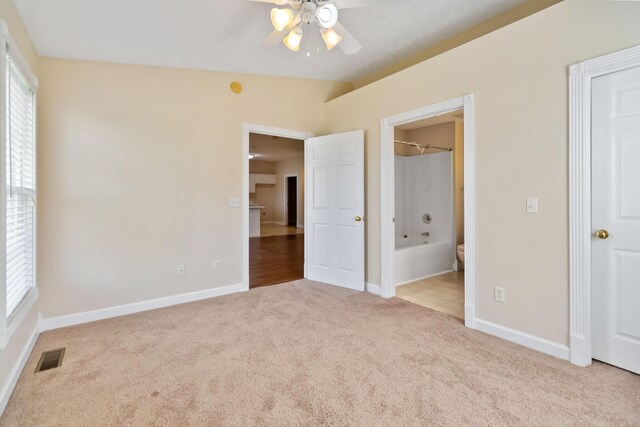 unfurnished bedroom with baseboards, carpet, and multiple windows