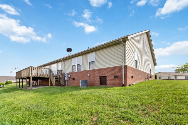 back of house featuring a deck, central AC unit, stairway, brick siding, and a yard