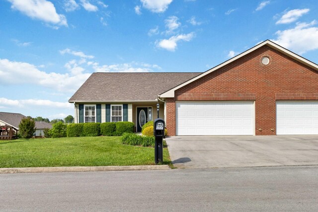 ranch-style house with an attached garage, brick siding, a front yard, and concrete driveway