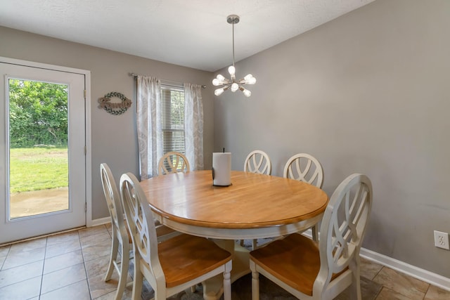dining space featuring baseboards, light tile patterned flooring, and a chandelier