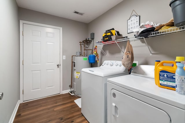 laundry room featuring laundry area, dark wood-style flooring, baseboards, electric water heater, and independent washer and dryer