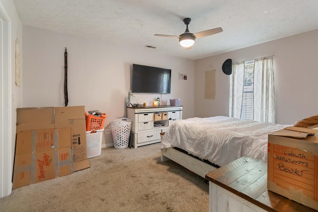 bedroom featuring visible vents, a textured ceiling, carpet, and ceiling fan