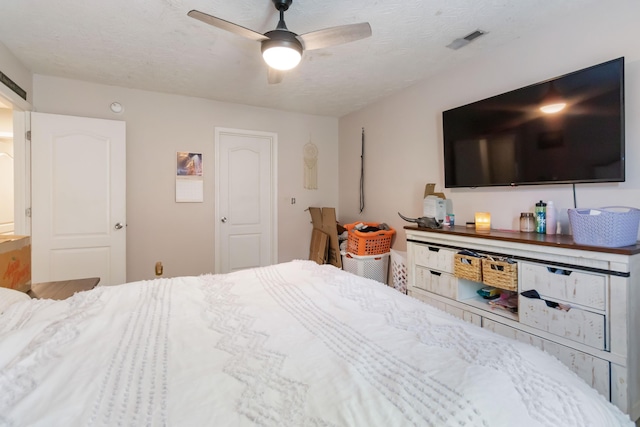 bedroom with visible vents, a ceiling fan, and a textured ceiling