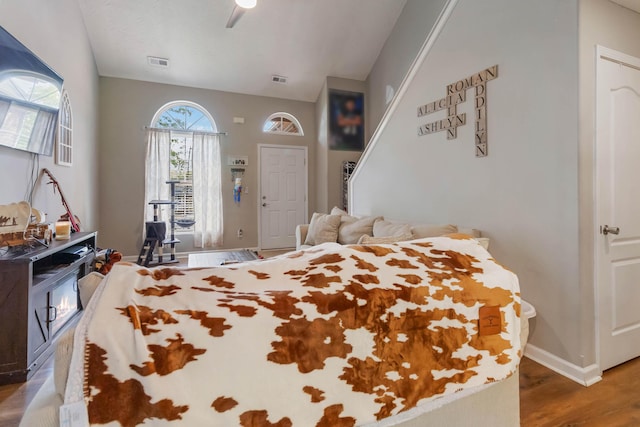 bedroom featuring baseboards, a ceiling fan, wood finished floors, and visible vents