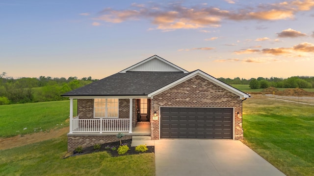 view of front of property with a garage, a lawn, driveway, and brick siding