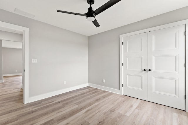 empty room with baseboards, ceiling fan, light wood-style flooring, and visible vents