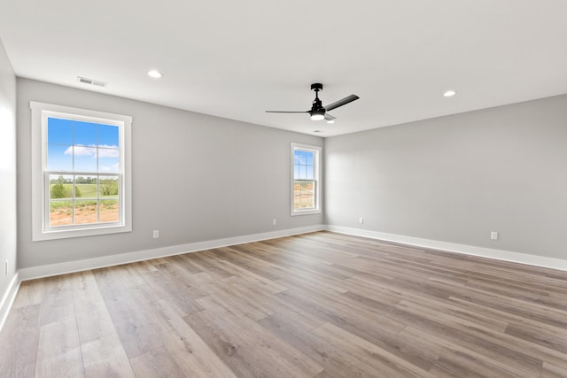 unfurnished room with baseboards, a ceiling fan, light wood-style flooring, and visible vents