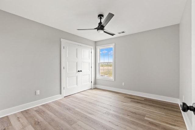 unfurnished bedroom with visible vents, a closet, baseboards, a ceiling fan, and light wood finished floors
