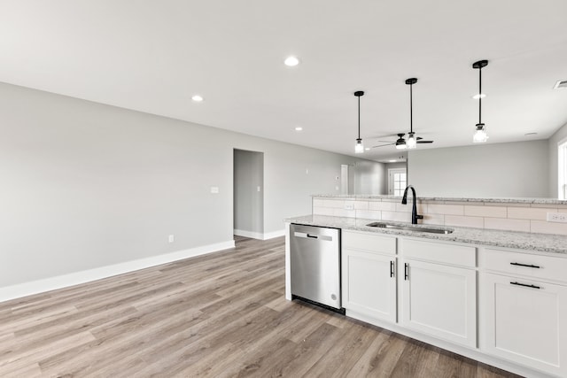 kitchen featuring a ceiling fan, pendant lighting, dishwasher, a sink, and light wood-style floors