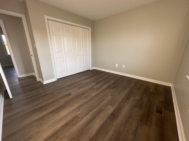 1072 Jenny Lilllard Rd, Lawrenceburg, KY 40342 - unfurnished bedroom featuring dark wood-type flooring, baseboards, visible vents, and a closet