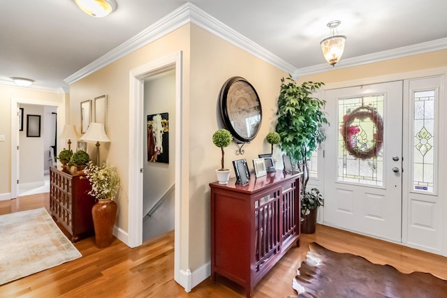 entrance foyer featuring ornamental molding, a wealth of natural light, and wood finished floors