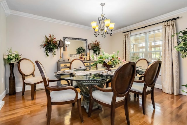 dining space featuring light wood-type flooring, baseboards, an inviting chandelier, and crown molding