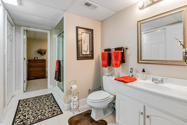 full bathroom featuring a stall shower, a drop ceiling, toilet, visible vents, and vanity