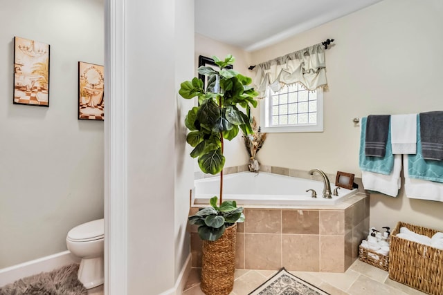 bathroom with a bath, toilet, and baseboards