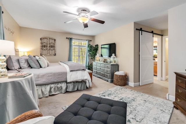 bedroom with a ceiling fan, carpet flooring, a barn door, and baseboards