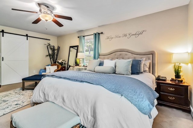 bedroom featuring carpet flooring, a barn door, and ceiling fan