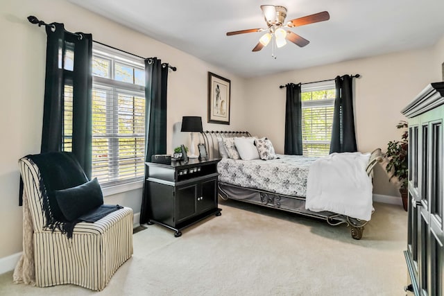 bedroom featuring light carpet, baseboards, and a ceiling fan