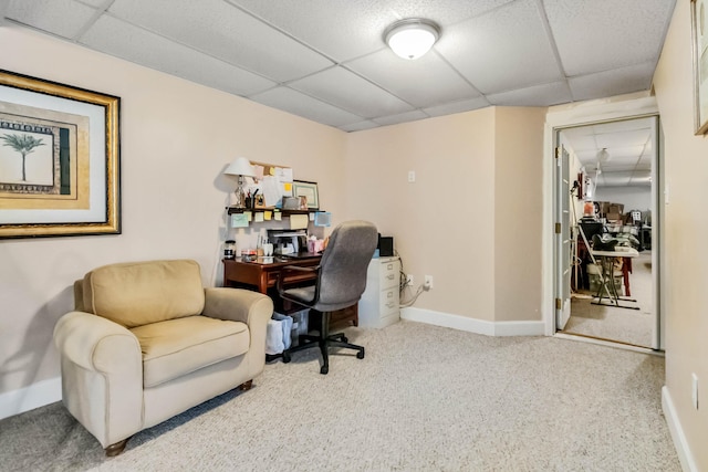 carpeted office featuring a paneled ceiling and baseboards