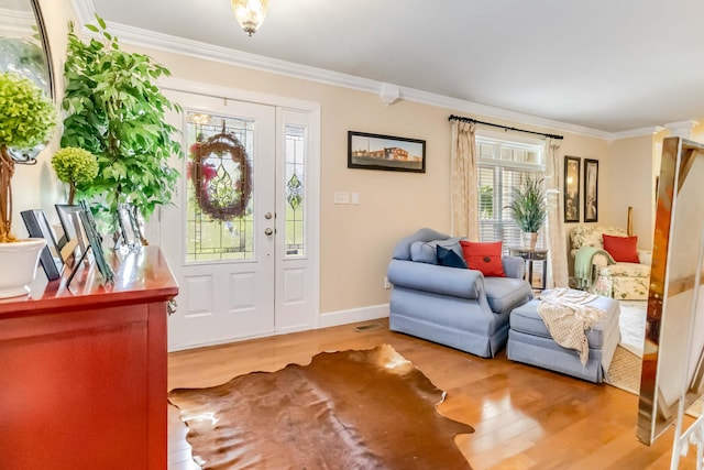entrance foyer with ornamental molding, baseboards, and wood finished floors