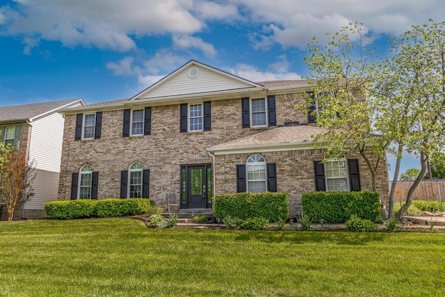 view of front of house with fence, a front lawn, and brick siding