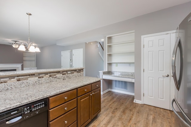 kitchen with brown cabinetry, freestanding refrigerator, an inviting chandelier, light wood-style flooring, and dishwasher