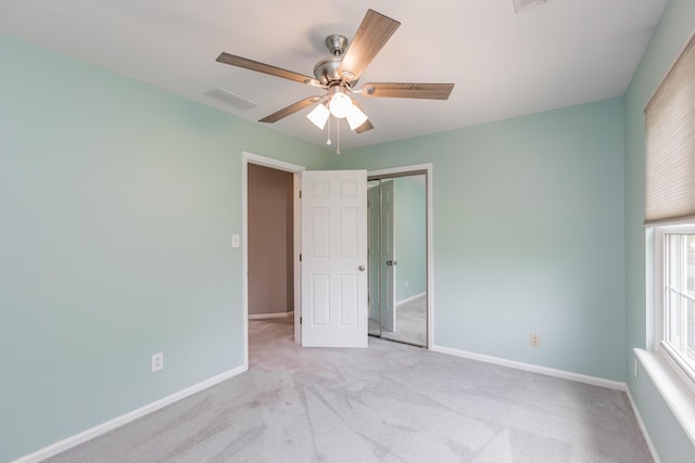unfurnished bedroom featuring a closet, baseboards, light colored carpet, and visible vents