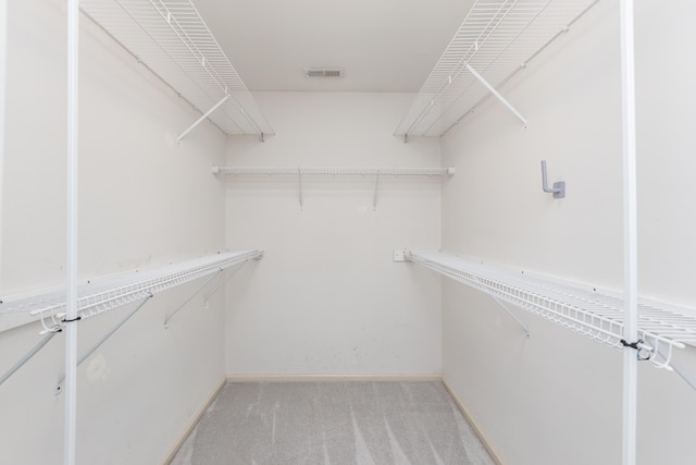 walk in closet with visible vents and light carpet