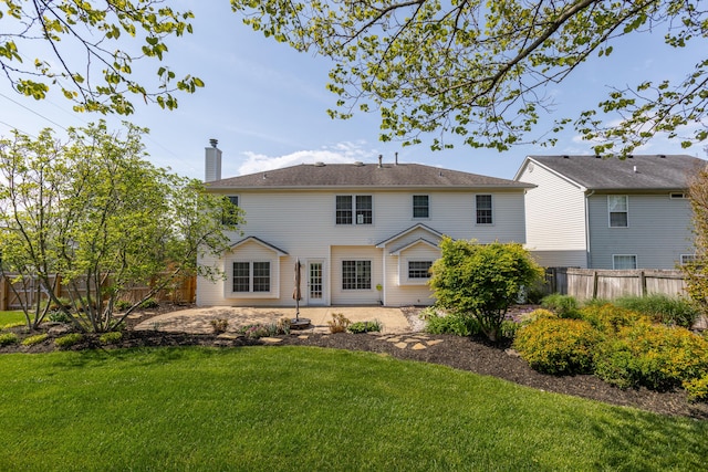 back of property with a patio, a fenced backyard, a yard, and a chimney