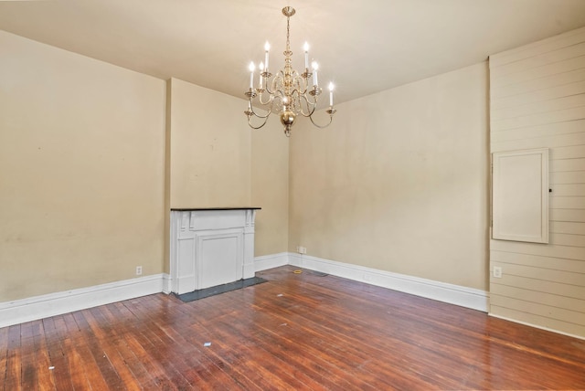 unfurnished room featuring dark wood-type flooring, baseboards, and a chandelier